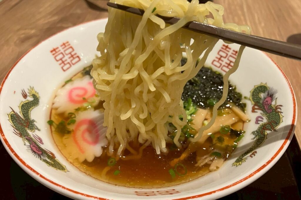 夜鳴きそばの麺をすするためにお箸で持っている