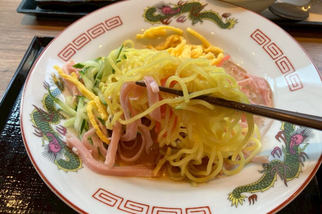 冷やし中華を箸でもって食べる