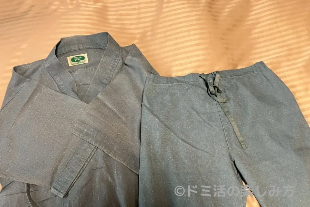 ホテル ルートインの部屋内のベッドの上に置かれた甚平の写真