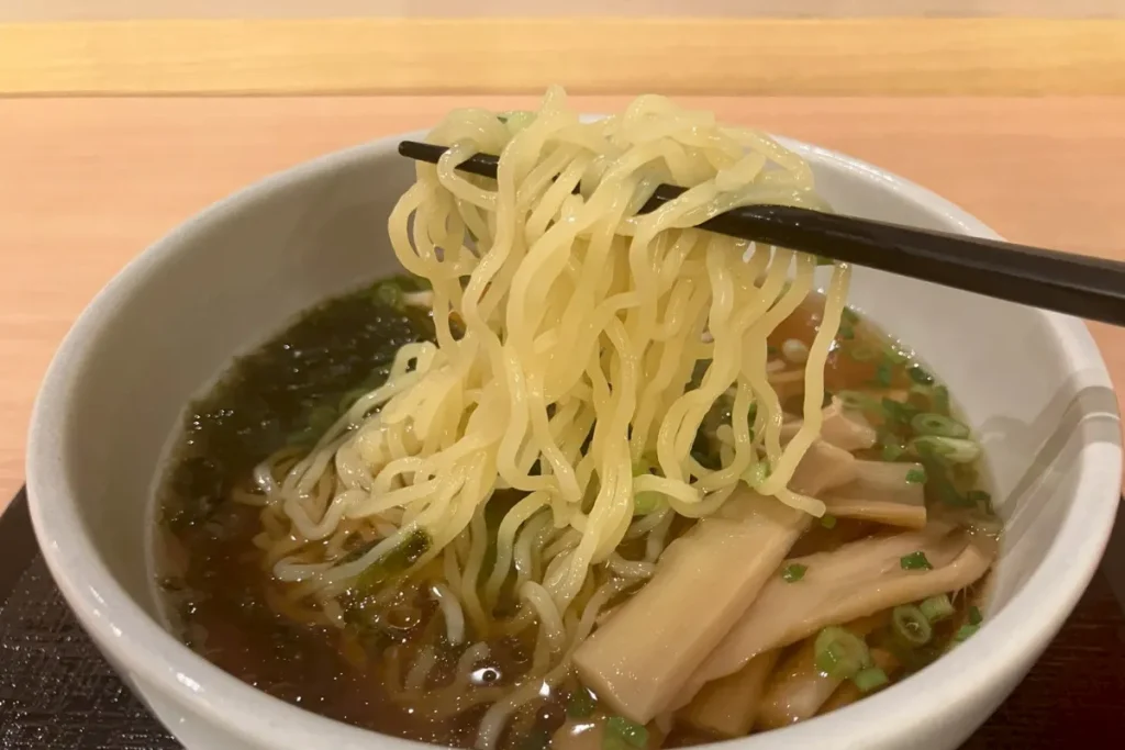 夜鳴きそばをお箸で食べるところ