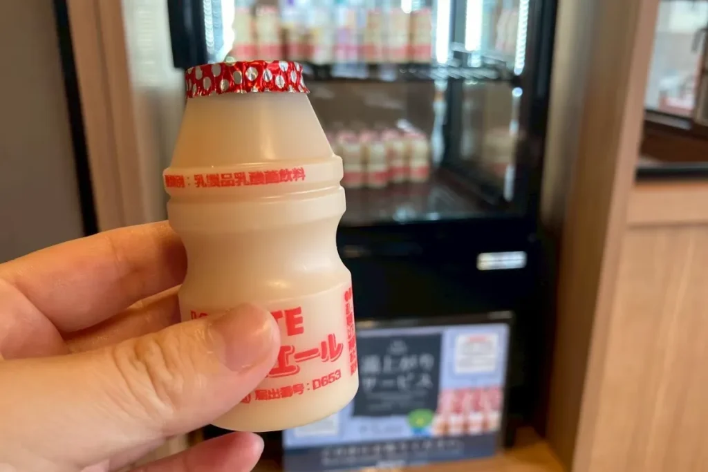ドーミーインにある乳酸菌飲料を手に取っている様子