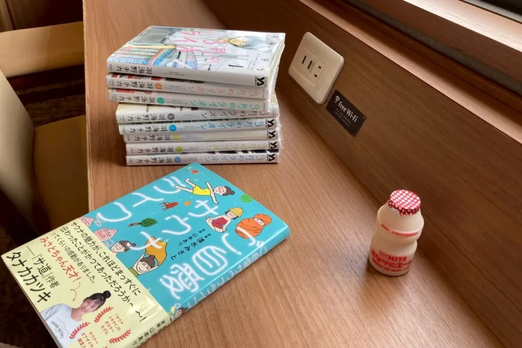 ドーミーインにある乳酸菌飲料を飲みながら漫画を読んでいる様子