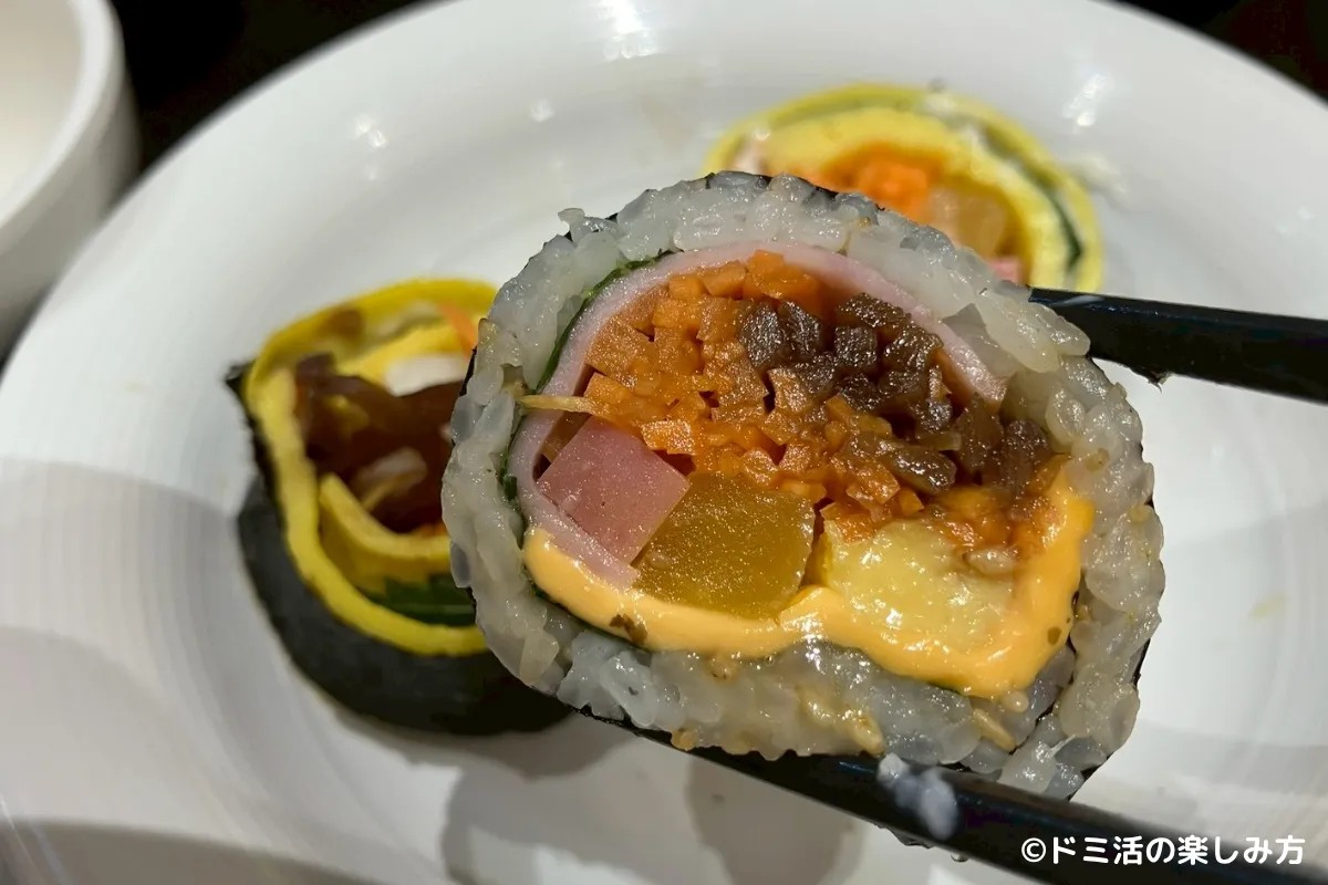 ドーミーインEXPRESSソウル仁寺洞の朝食バイキングのキンパをお箸で上げている写真