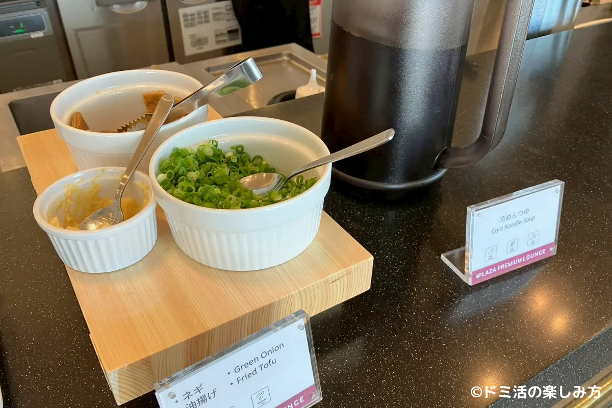 プラザプレミアムラウンジ名古屋のキッチンカウンターにあるうどんのめんつゆと薬味の写真