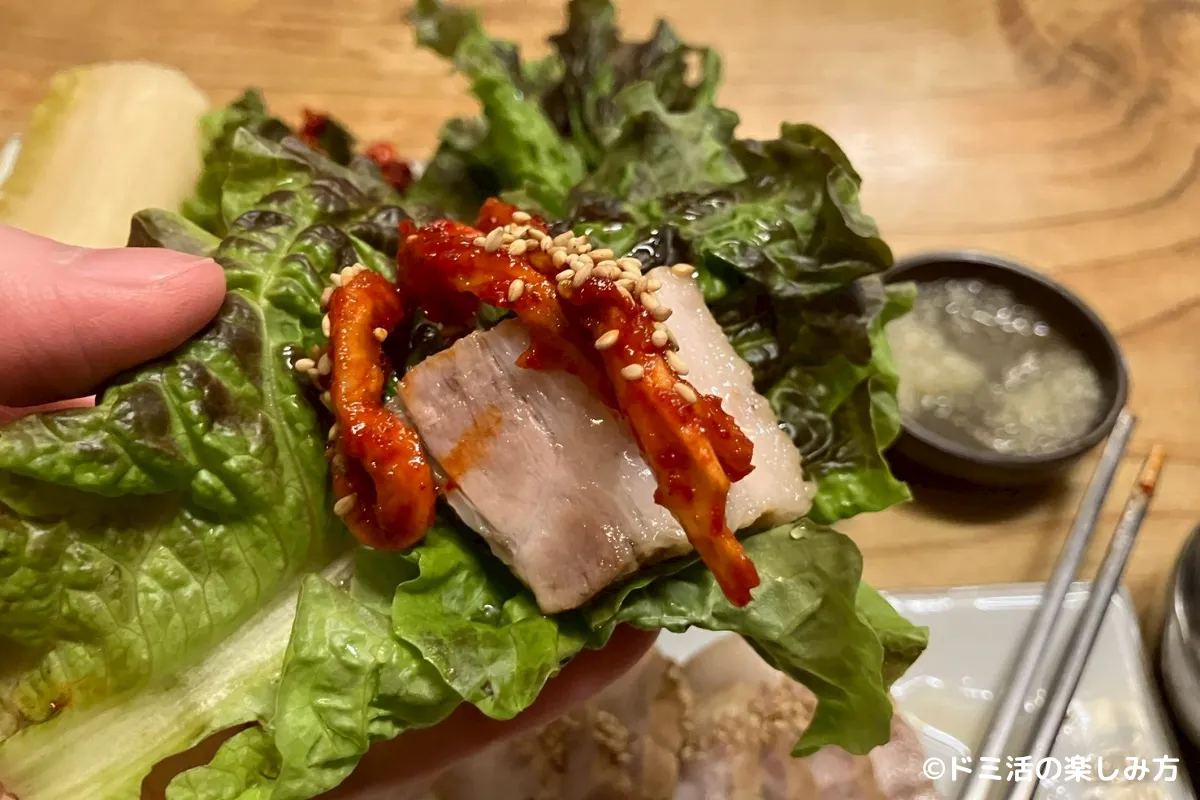仁寺洞マヌルポッサムで豚肉をサンチュで包んでいる写真