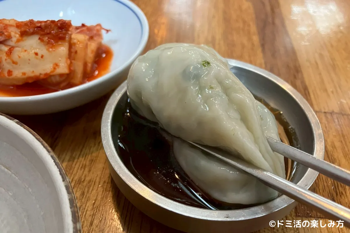 仁寺洞にあるカフェ「伝統茶院」の目の前にあるマンドゥ屋さん「開城ギョーザ」のマンドゥをたれにつけている写真