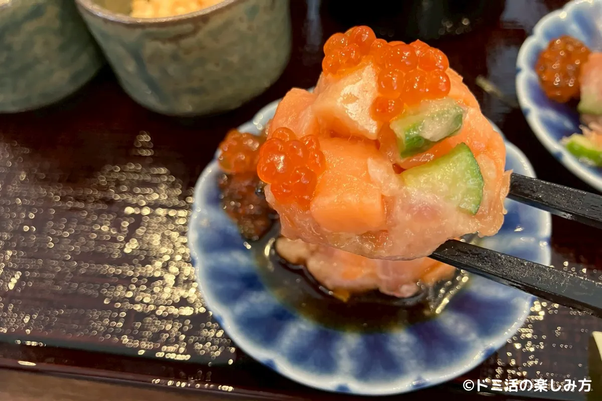 ドーミーイン千歳の朝食でいくらとサーモンの海鮮手まりをお箸で持ち上げている写真