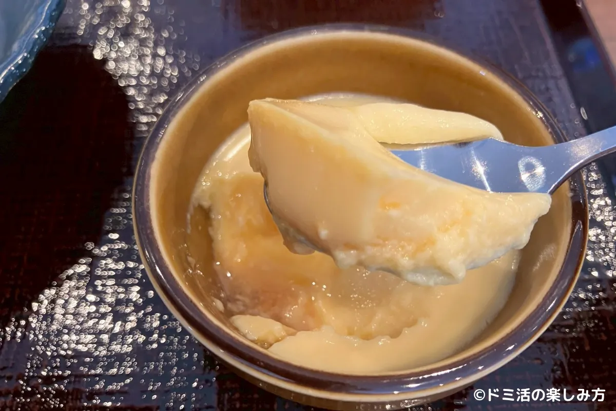 ドーミーイン千歳の朝食のなめらかチーズプリンをスプーンですくっている写真