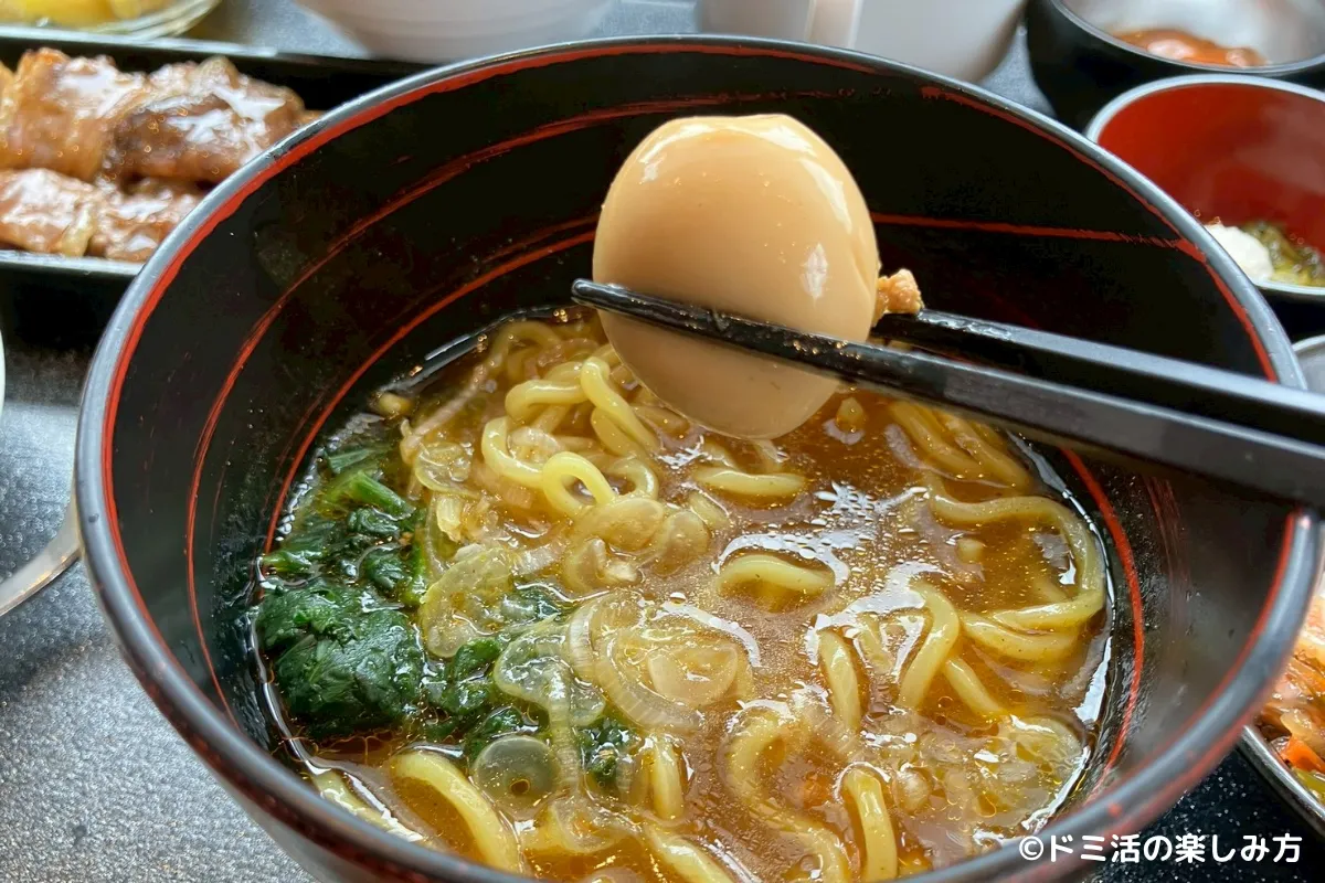 室蘭カレーラーメンのうずらの卵をお箸で持っている写真