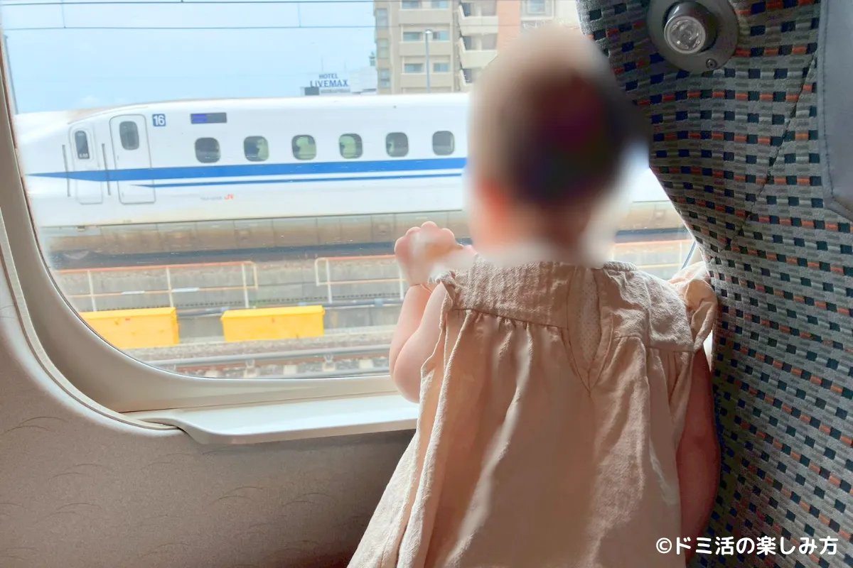私の1歳の子供が窓の外の新幹線を見ている写真